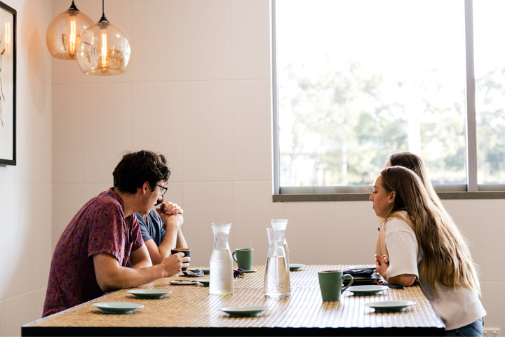 Group of four people around a table socialising